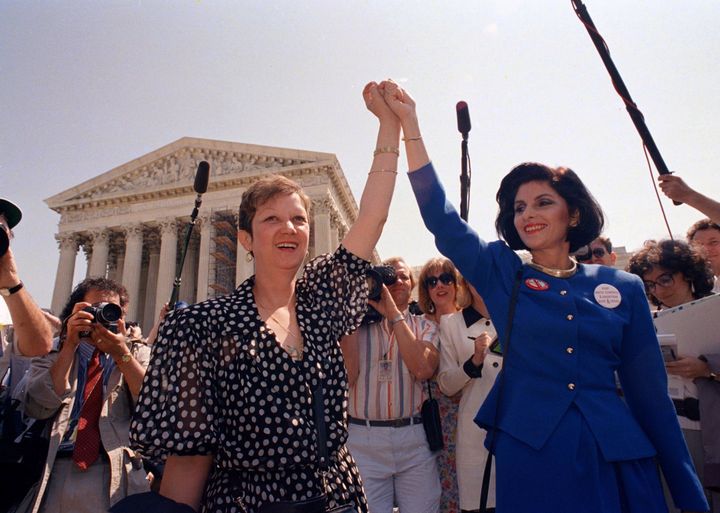 In this April 26, 1989, file photo, Norma McCorvey, Jane Roe in the 1973 court case, left, and her attorney Gloria Allred hold hands as they leave the Supreme Court building in Washington after sitting in while the court listened to arguments in a Missouri abortion case.