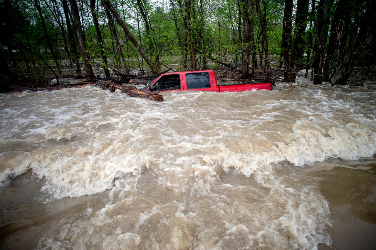 Tittabawassee Fire and Rescue rescued the driver from this red pickup truck on Tuesday in Saginaw County, Mich. The truck was swept off of the road by standing water. (Jake May/The Flint Journal via AP)/
