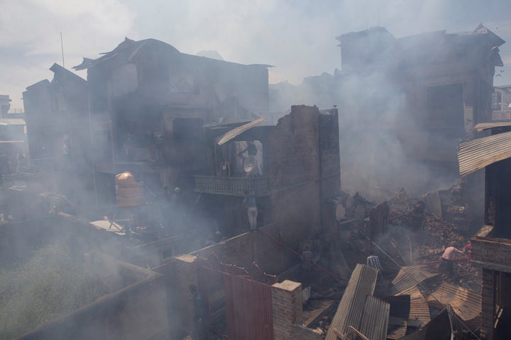 Kashmiri men douse the fire in a house which was destroyed in a gun-battle in Srinagar, Jammu and Kashmir, on Tuesday, May 19, 2020.