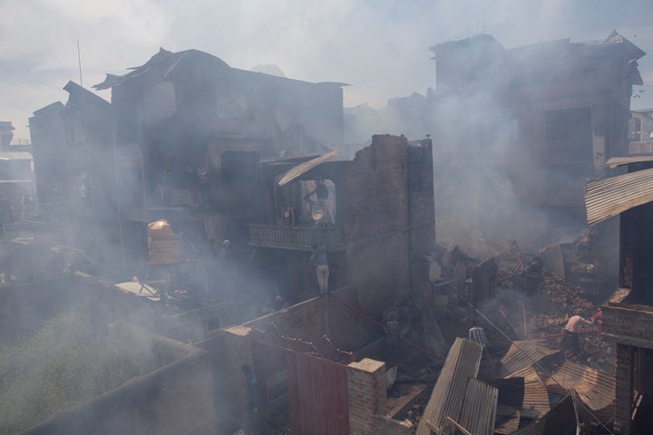 Kashmiri men douse the fire in a house which was destroyed in a gun-battle in Srinagar, Jammu and Kashmir, on Tuesday, May 19, 2020. 