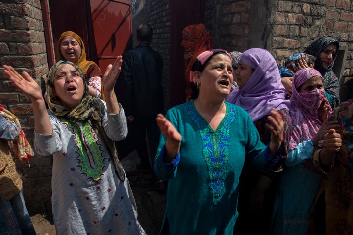 Kashmiri women grieve near the residential buildings damaged during a gun battle in Srinagar, Jammu and Kashmir on Tuesday, May 19, 2020.
