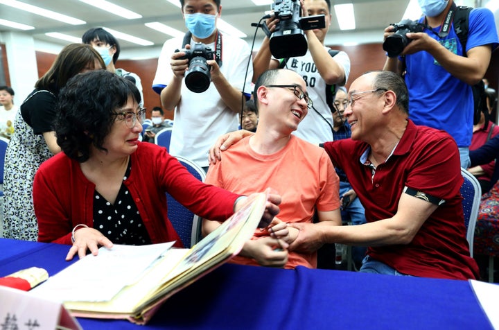 This photo taken on May 18, 2020 shows Mao Yin (C) speaking with his mother Li Jingzhi (L) and father Mao Zhenping (R) in Xian, in China's northern Shaanxi province. - A Chinese man who was kidnapped as a toddler 32 years ago has been reunited with his biological parents, after police used facial recognition technology to track him down. (Photo by STR / AFP) / China OUT (Photo by STR/AFP via Getty Images)