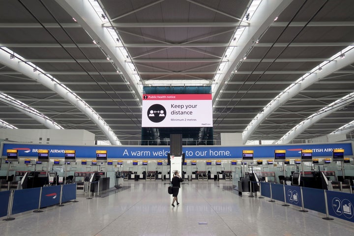 A woman walks at Heathrow Airport in London on May 1. The U.K.'s health secretary has suggested that international holiday travel is off the table this summer, but airlines are pushing to get travel going again.