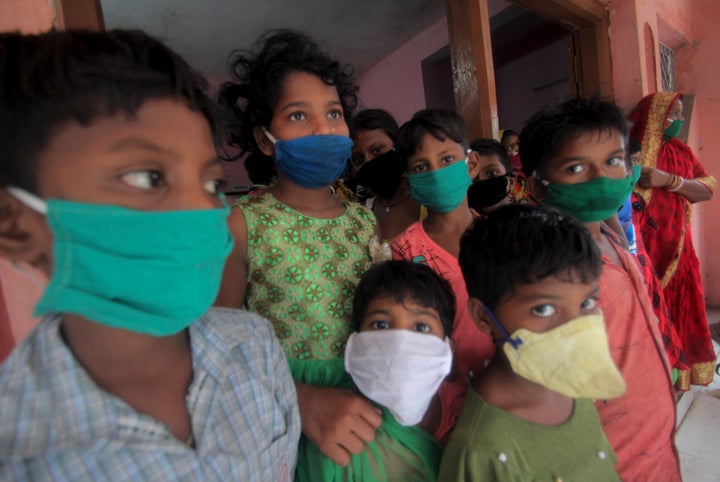 Evacuated children wearing masks as a precaution against the spread of coronavirus stand at a relief camp at Paradeep, on the