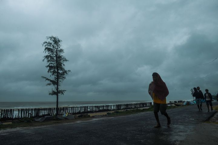 People walk along a road near the Tajpur Beach to take shelter ahead of the expected landfall of cyclone Amphan in Midnapore, West Bengal, on May 20, 2020.