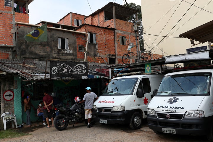 People gather next to ambulances on March 29, 2020, after residents of São Paulo's biggest favela, Paraisópolis, hired an around-the-clock private medical service to fight COVID-19.