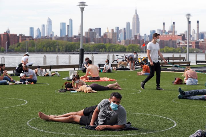 People relax in circles drawn to help social distancing at Domino Park in Brooklyn, New York.