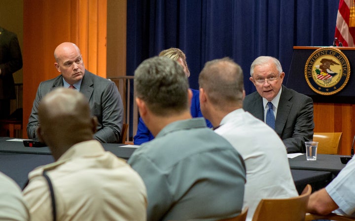 Matthew Whitaker looks over at then-Attorney General Jeff Sessions during a roundtable discussion with foreign liaison officers at the Justice Department in Washington on Aug. 29, 2018. 