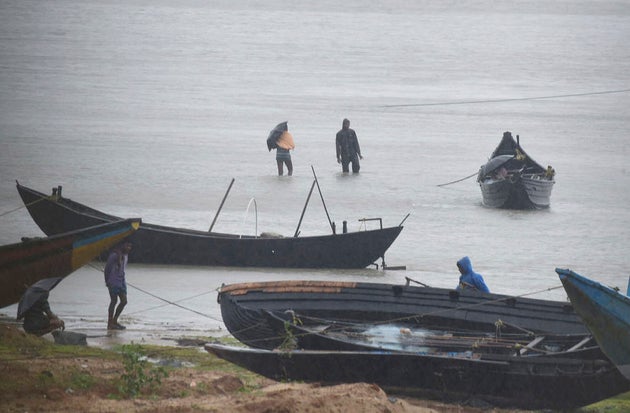 Fishermen are trying to pull their fishing boats back at Talasari beach in heavy wind and rain in Balasore,...