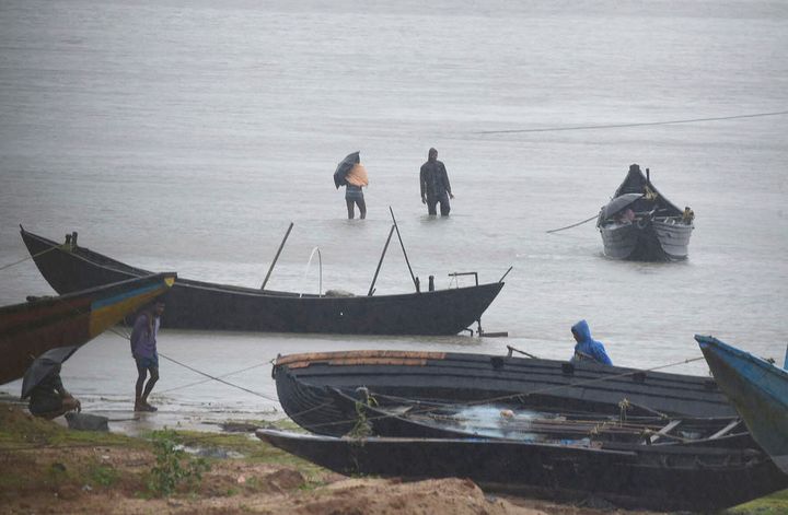 Fishermen are trying to pull their fishing boats back at Talasari beach in heavy wind and rain in Balasore, India, May 20, 2020. 