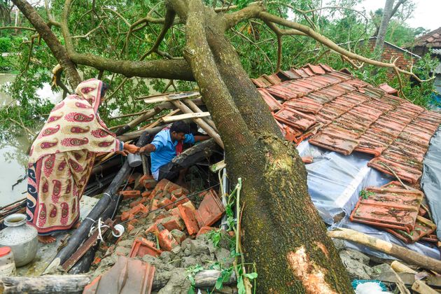 Des villageois récupèrent des objets dans leur maison détruite par le cyclone Amphan...