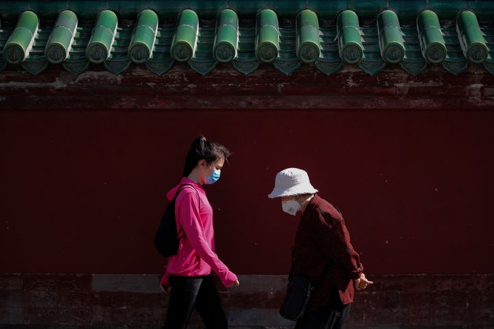 Women wearing protective face masks walk in Beijing, May 10, 2020.