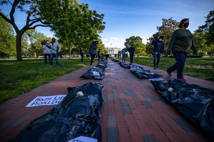 Signs affixed to body bags read “Trump Lies, People Die,” symbolizing the nearly 100,000 people in the U.S.