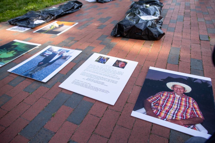 Progressive activists outside the White House in Washington D.C. lay body bags and photos of loved ones killed by the coronav