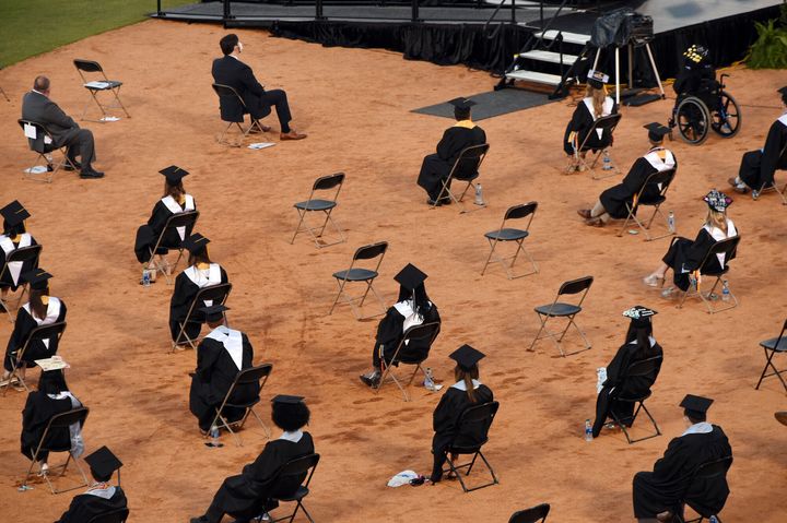 In this Wednesday, May 20, 2020 photo, Spain Park High School graduates attend their graduation ceremony while maintaining social distancing guidelines at the Hoover Met, in Hoover, Ala. Everyone attending the ceremony also had to wear a mask as a precaution against the spread of the coronavirus. (Joe Songer/The Birmingham News via AP)