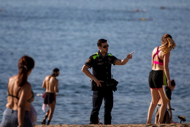 Un policía vigila que se cumplan las medidas de seguridad en una playa de