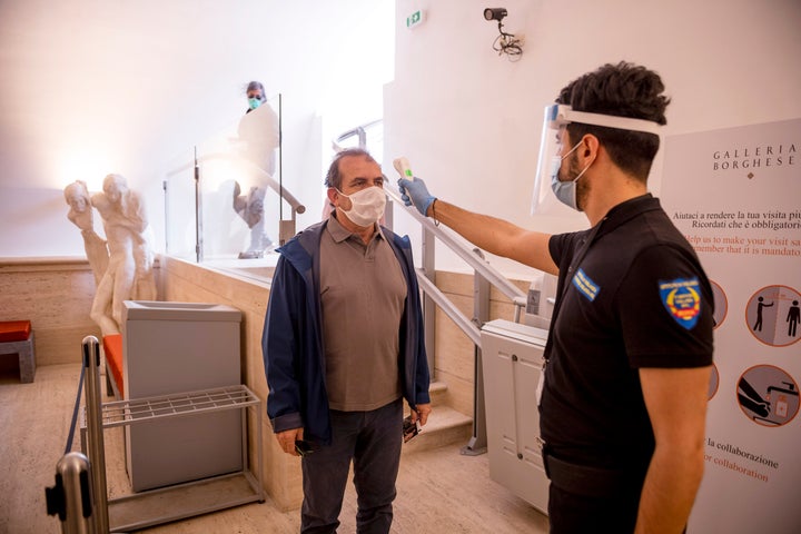 A staff member at Rome's Galleria Borghese checking a visitor's temperature on Tuesday.