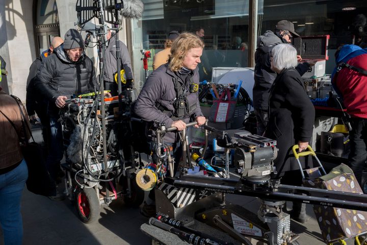 A film industry crew remove camera and sound equipment from a location among members of the public in Kingston town centre, after filming outside in the street.