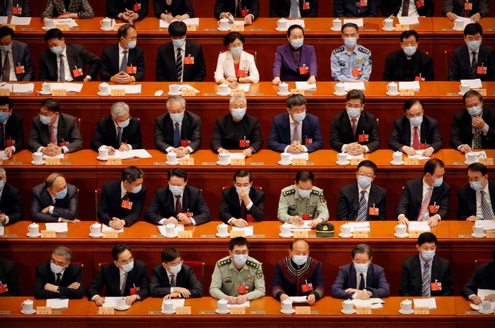 Delegates wearing face masks to protect against the spread of the new coronavirus wait for the start of the opening session o