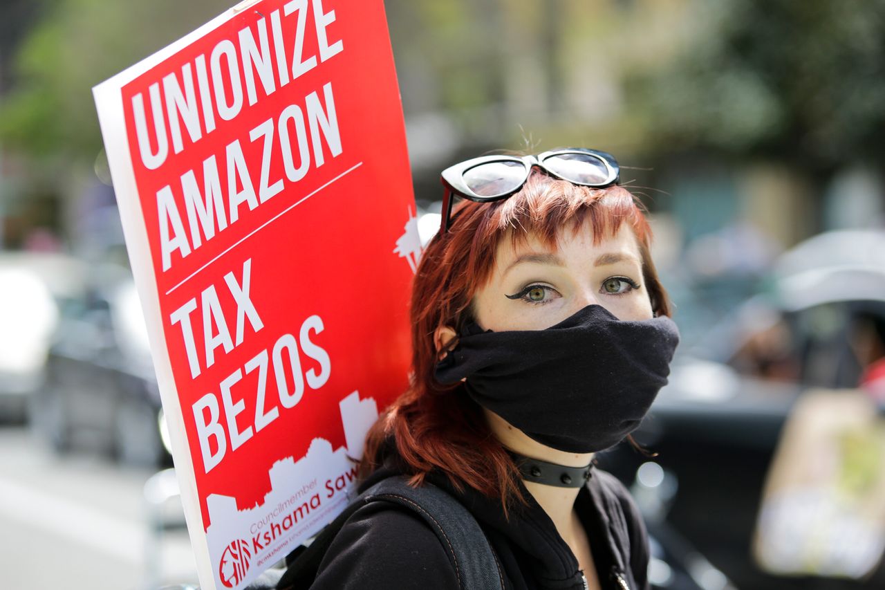 Some Amazon workers have spoken out about working conditions during the pandemic, even though the company is nonunion. Here, a protestor holds a sign at the Amazon Spheres in Seattle on May 1.