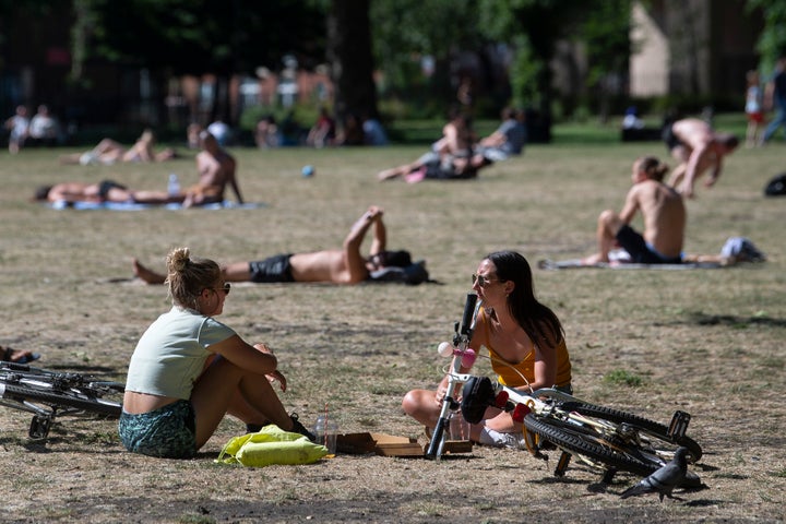 People enjoy the sun in London Fields park in East London.