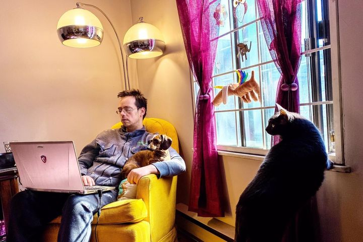 "This is how quarantine looks for my family; open windows so the cat can hear the birds, lots of midday snuggles for the dog and my husband working from his favorite chair."