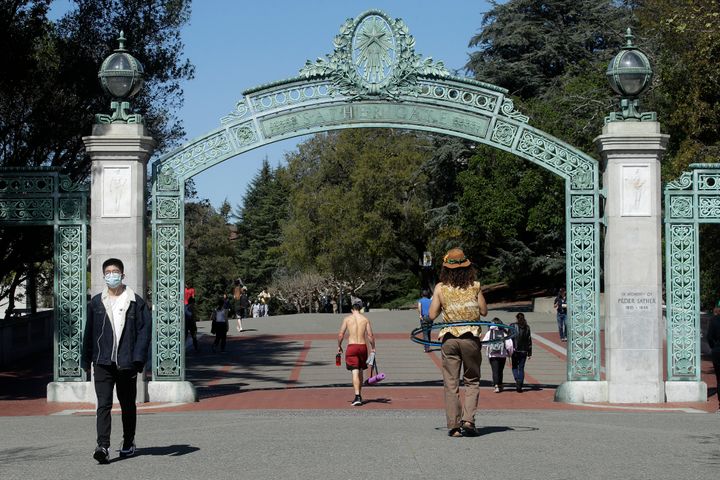 A man wears a mask while walking past Sather Gate on the University of California, Berkeley, campus on March 11, 2020.