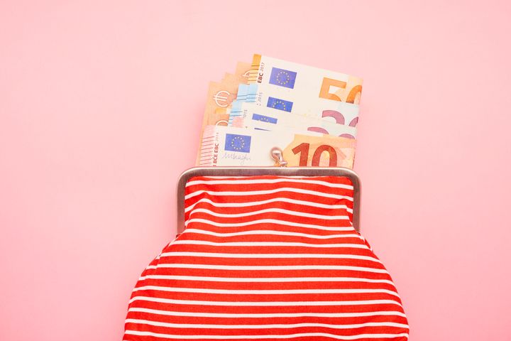Directly above shot of a wallet and Euro banknotes on pink background