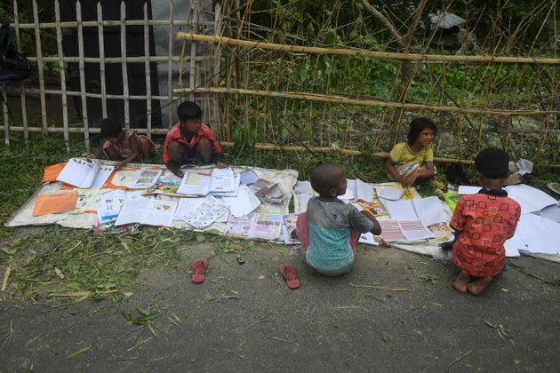Children lay out their wet textbooks to dry following the landfall of cyclone Amphan in Khejuri area...