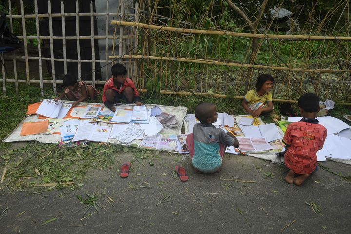 Children lay out their wet textbooks to dry following the landfall of cyclone Amphan in Khejuri area of Midnapore, West Bengal, on May 21, 2020