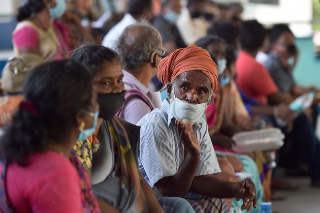 A migrant worker from Tamil Nadu waits to be screened along with other workers before travelling in a...