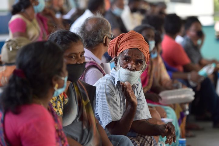 A migrant worker from Tamil Nadu waits to be screened along with other workers before travelling in a special train to his home state, at Ambedkar Stadium, on May 16, 2020 in New Delhi.
