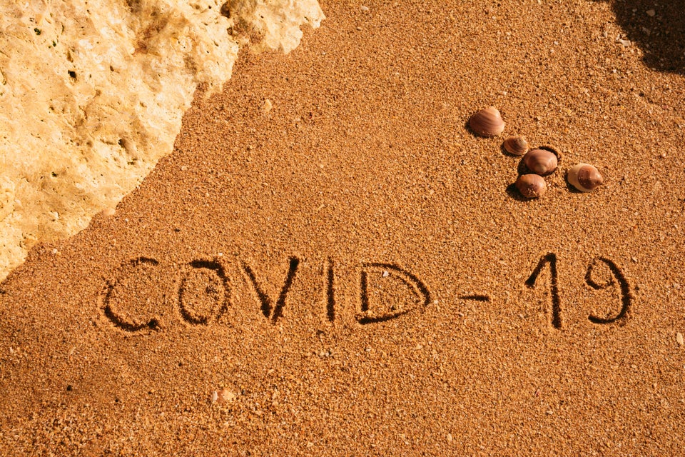 Travel and tourism concept for pandemic alert, flights and trips cancellation.  Text written on the sandy beach in Algarve.