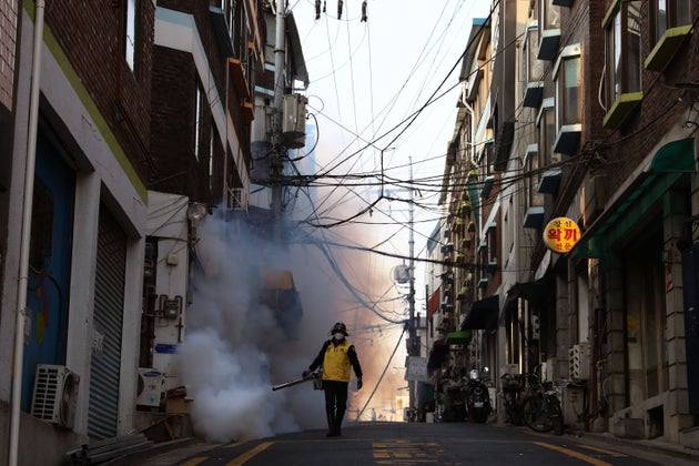 A South Korean man in Seoul disinfects an alley to prevent the spread of coronavirus, March 18, 2020.