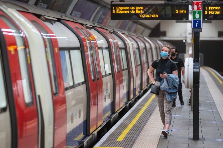 A commuter wearing a protective face mask walks along the platform at Clapham Common underground station, London, as train services increase this week as part of the easing of coronavirus lockdown restrictions.
