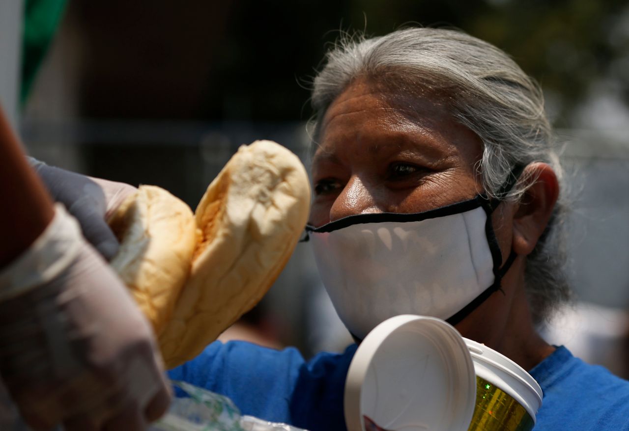Γυναίκα στο Μεξικό απλώνει τα χέρια για πάρει φαγητό από το συσσίτιο που προορίζεται για τις οικογένειες που λόγω κορονοϊού δεν εργάζονται και δεν έχουν εισόδημα (20 Μαϊου)