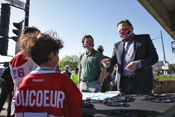 Jonathan Drouin et François Legault distribuant des masques.
