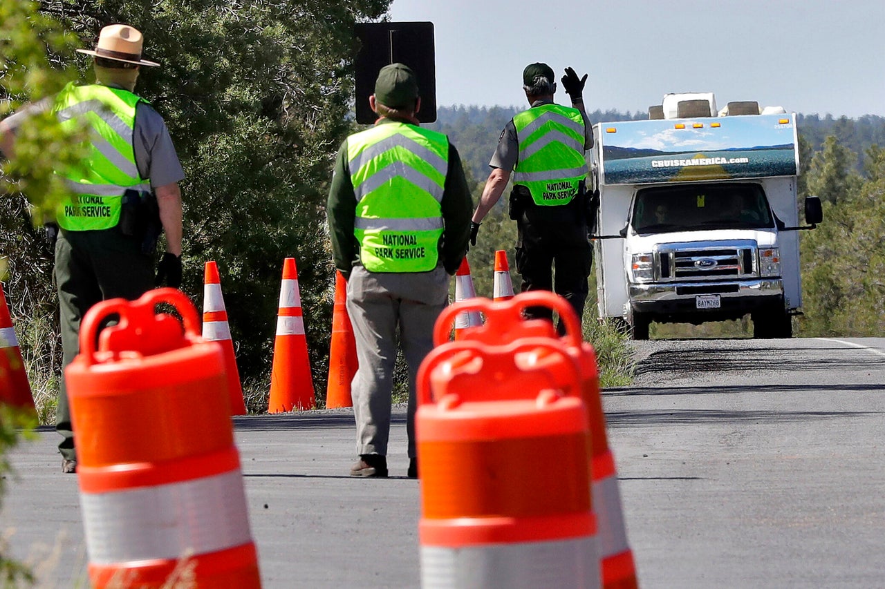 U.S. Park Rangers wave through the final visitor of the day before closing the entrance to the Grand Canyon for the day on May 15. The National Park Service is using a phased approach to increase access on a park-by-park basis during the COVID-19 pandemic.