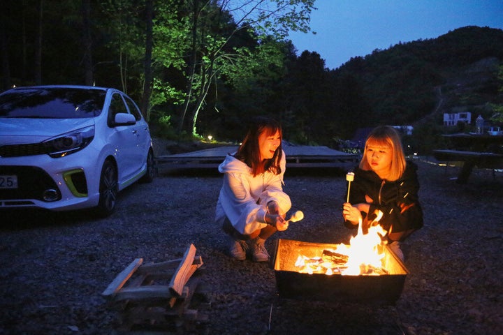 지난 14일 경기 가평군 설악면 ‘새와참새 캠핑장’. 김주현(오른쪽)·윤지혜씨가 경차 ‘모닝’ 차박에 앞서 화롯불에 마시멜로를 굽고 있다.