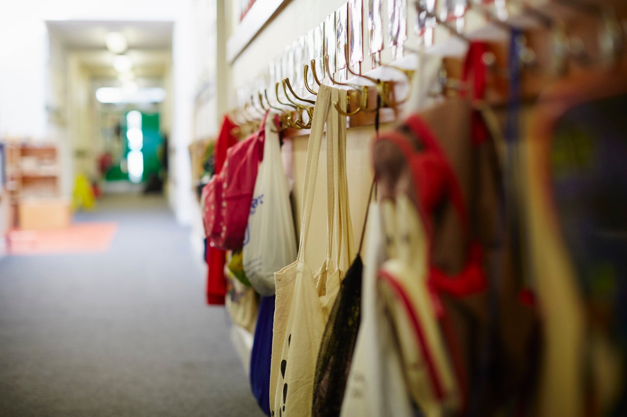 School bags hanging on row of coat hooks in elementary school