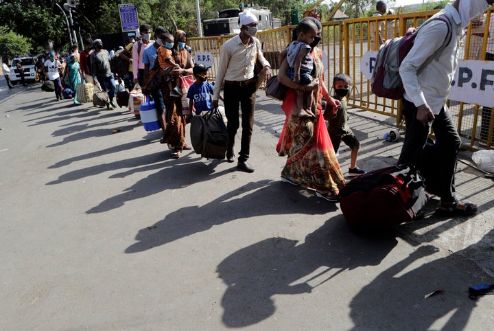 People from other states trying to get back to their homes arrive to board trains at the Chhatrapati Shivaji Maharaj Terminus in Mumbai, May 19, 2020.