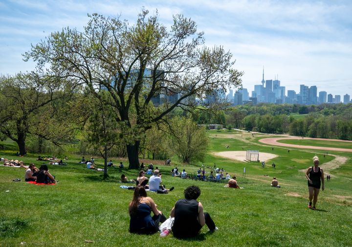 Park visitors soak up the sun in Toronto on May 23, 2020. Warm weather and a reduction in COVID-19 restrictions have many looking to the outdoors for relief. 