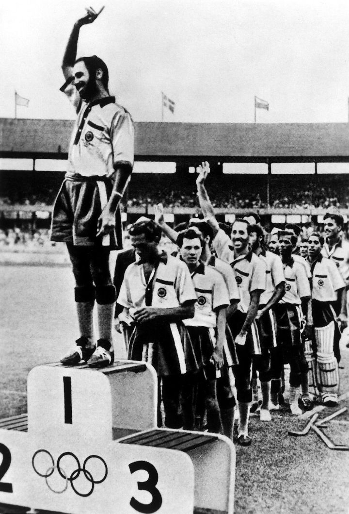 Field hockey, men: award ceremony for the winning Indian team, captain Balbir Singh on the winner's rostrum waving to the audience