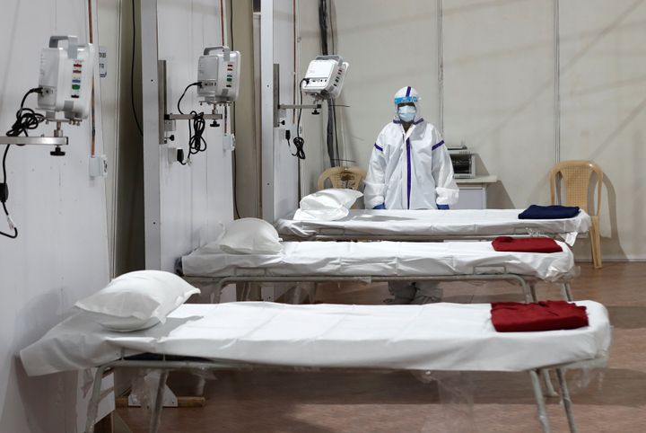 A woman wearing a protective suit stands next to beds inside a hospital that has been constructed to treat patients who test positive for the coronavirus disease (COVID-19) in Mumbai, May 22, 2020.