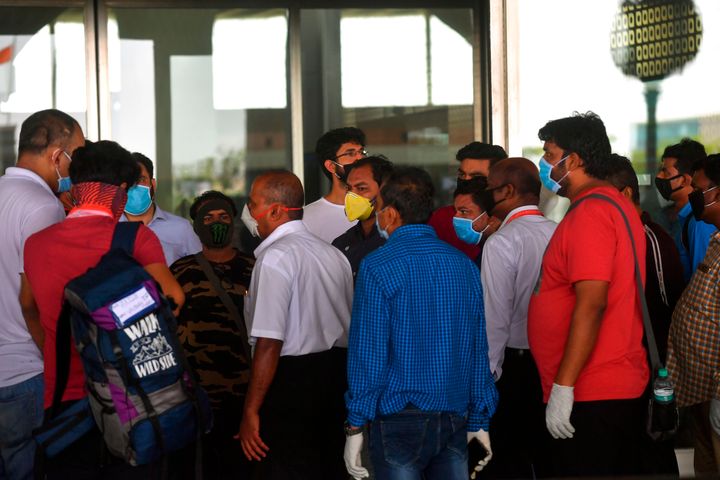 Passengers gather around an Air India official as their flight was cancelled at Chhatrapati Shivaji Maharaj International Airport in Mumbai on May 25, 2020.