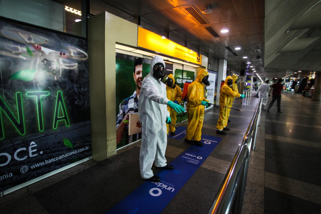 Workers disinfect an area of Belém International Airport.