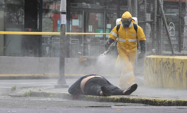 Ψεκασμός της σορού ενός άνδρα που πέθανε ξαφνικά και έπεσε στη μέση του δρόμου. Οι αρχές στο Εκουαδόρ πρέπει να λάβουν όλα τα απαραίτητα μέτρα καθώς δεν γνωρίζουν εάν πέθανε από κορονοϊό. 