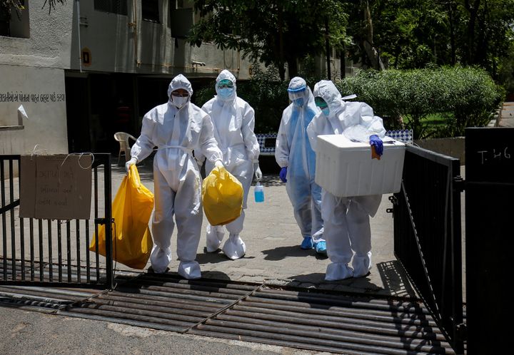 Health workers wearing protective gear leave after collecting samples during a door-to-door verification in a residential area in Ahmedabad, April 29, 2020.