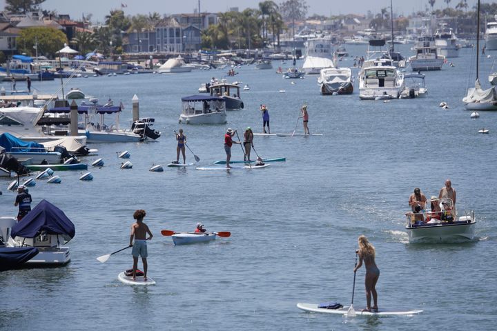 Boaters and paddle boarders use a harbor Sunday, May 24, 2020, in Newport Beach, Calif. (AP Photo/Marcio Jose Sanchez)