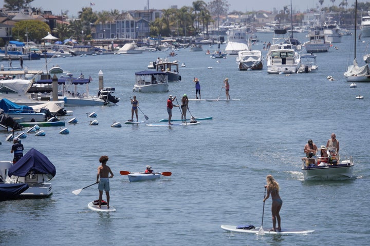 Boaters and paddle boarders use a harbor Sunday, May 24, 2020, in Newport Beach, Calif. (AP Photo/Marcio Jose Sanchez)